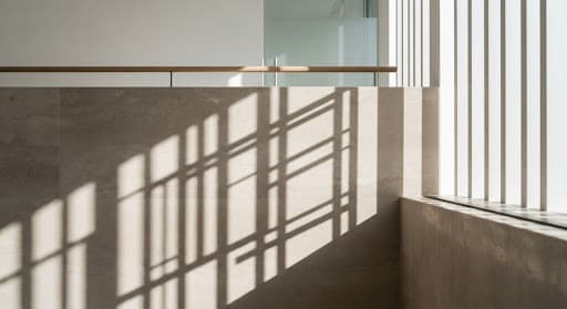 Détail architectural où la lumière projette des ombres géométriques sur une surface de pierre polie
